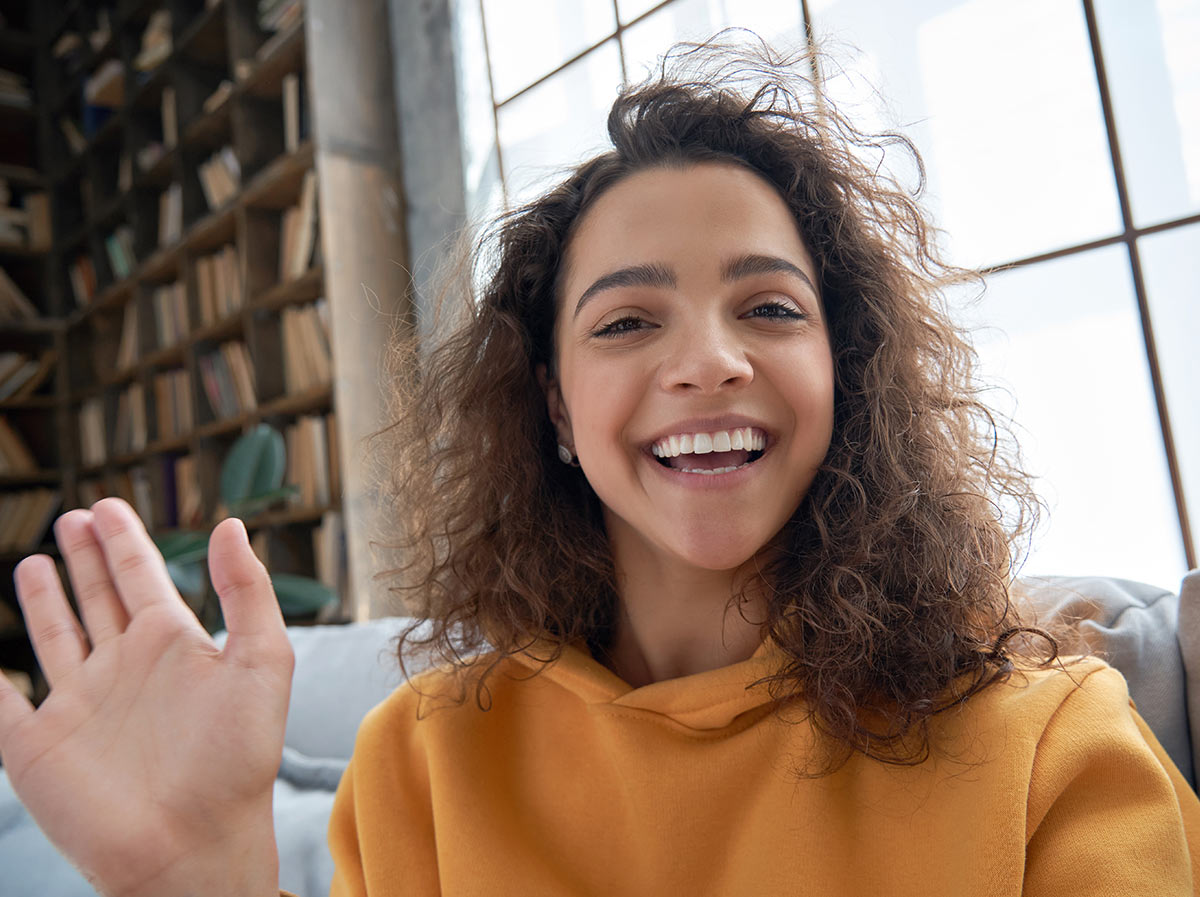 A smiling social media influencer takes a selfie to send to her followers using an SMS & MMS influencer outreach platform